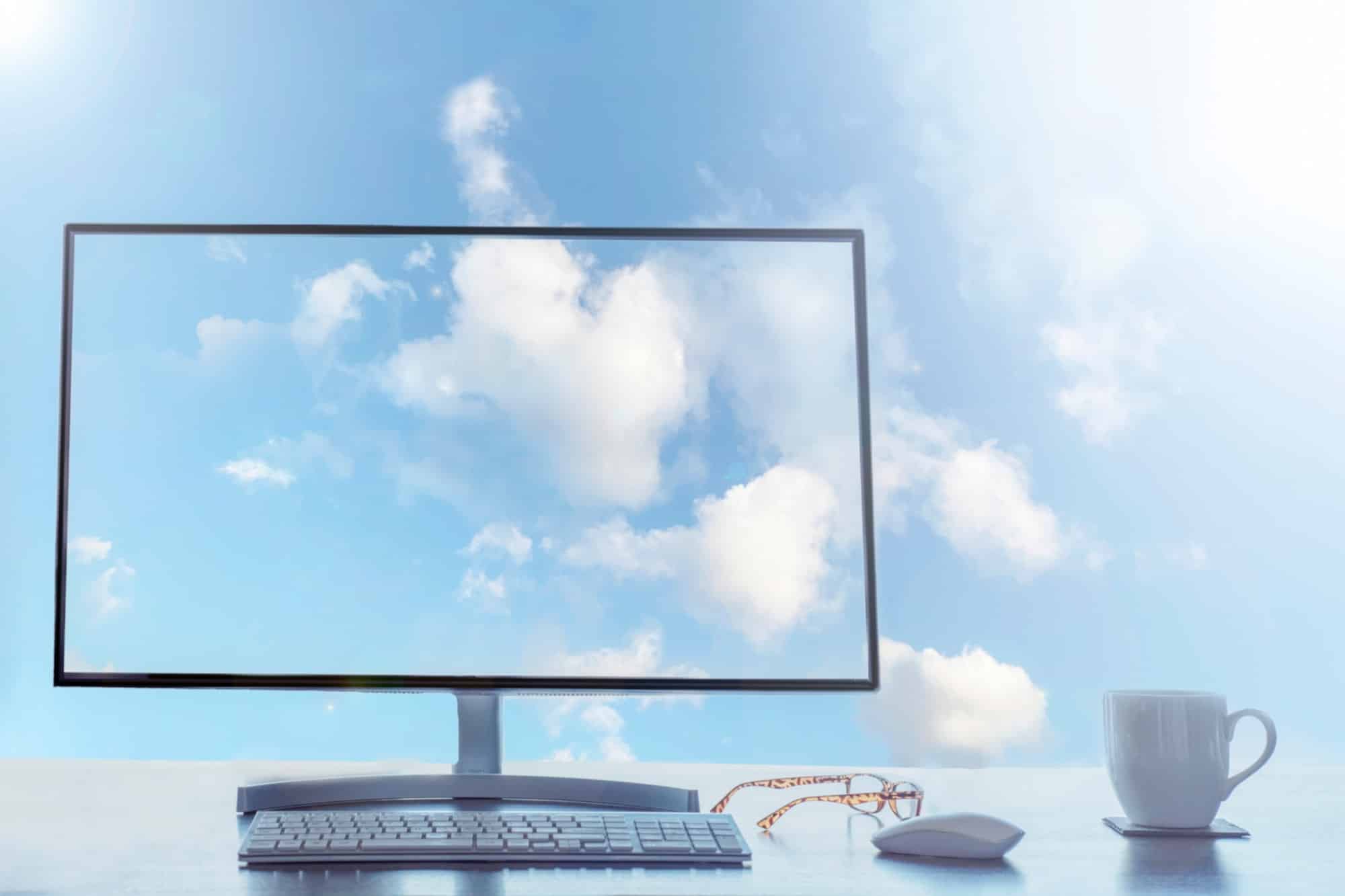Office in the sky, cloud computing concept. Desktop with keyboard, mouse and coffee.